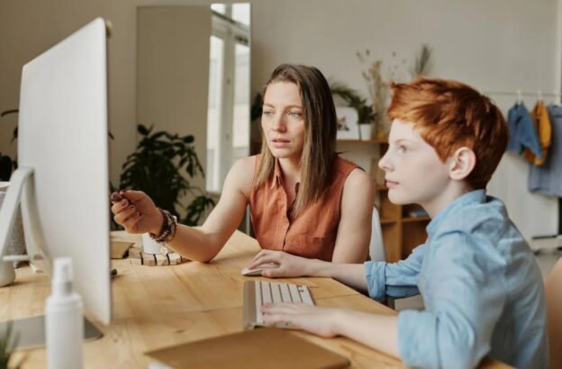 child and parent looking at computer screen